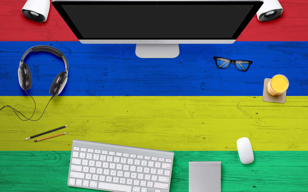 mauritius-flag-background-with-headphonecomputer-keyboard-and-mouse-on-national-office-desk-table-top-view-with-copy-space-flat-lay