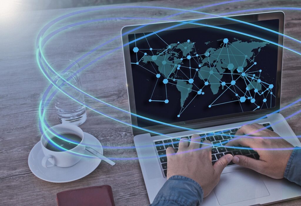 Compliance costs - automated compliance for a multinational company - a man working on a PC with a global map network.