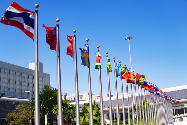 A row of flagpoles with flags for the countries around the world - Global Minimum Tax.