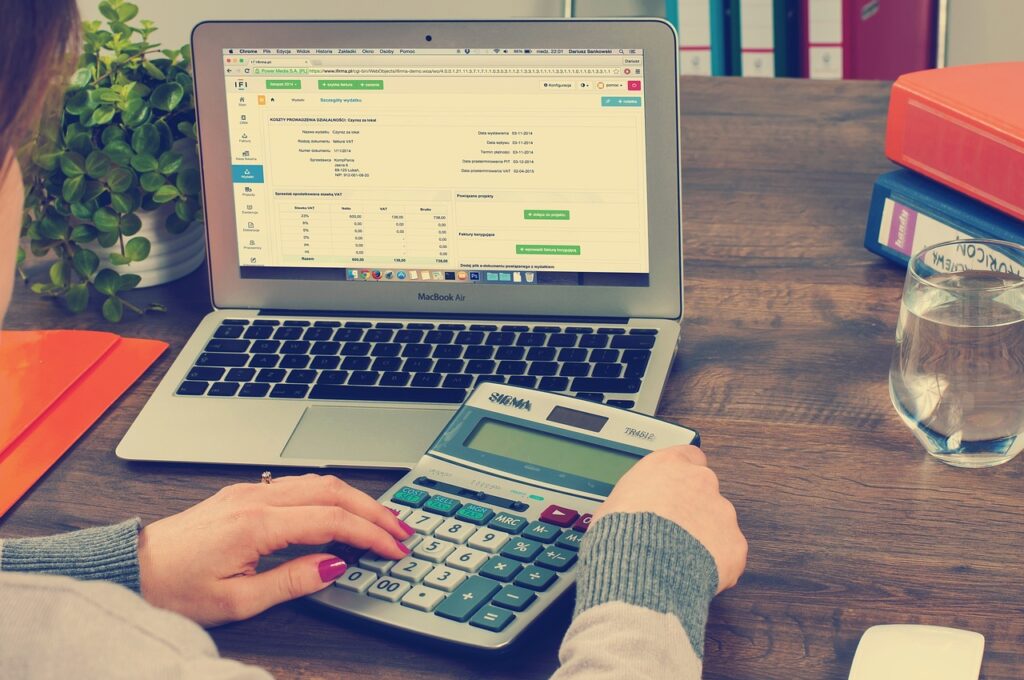An accountant using a computer and calculator to manage the accounts.