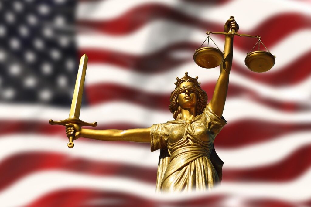 Lady Justice stood in front of an American flag.