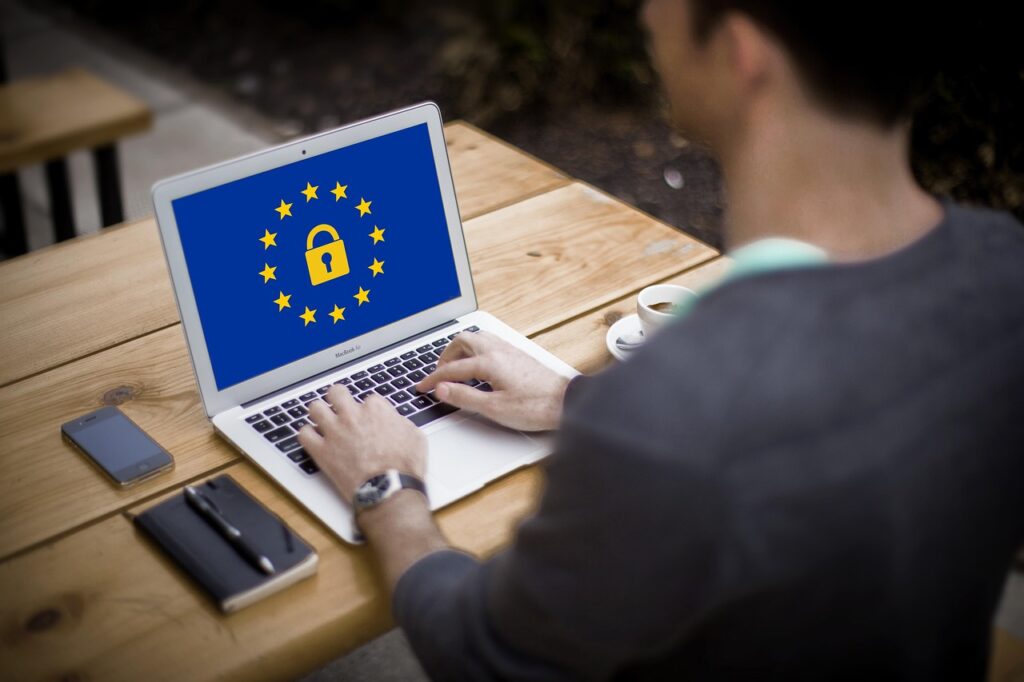 A man working on a laptop that shows the GDPR logo.
